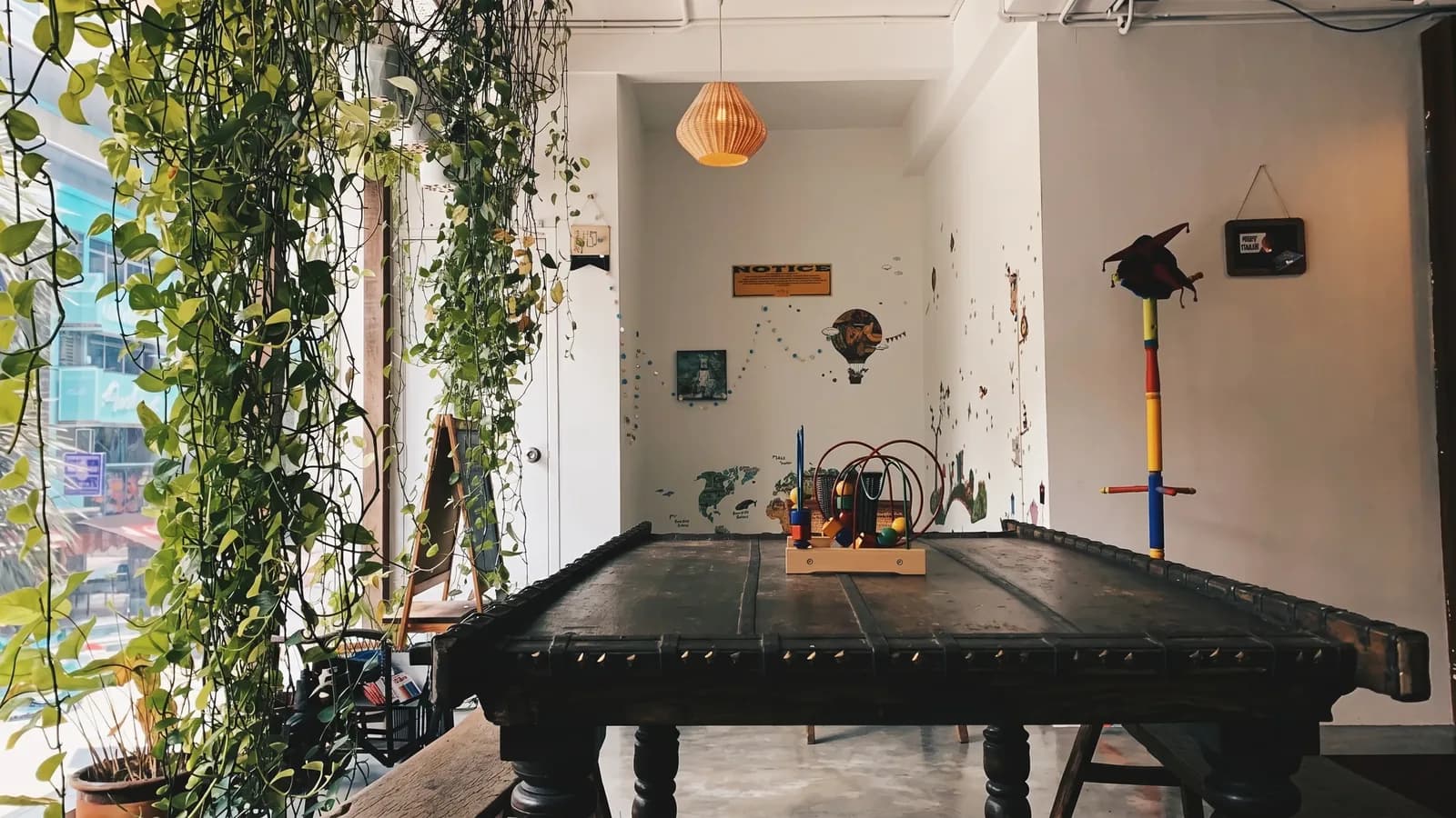 The Mind Faculty's light-filled common room, hanging plants by the window and a long communal table